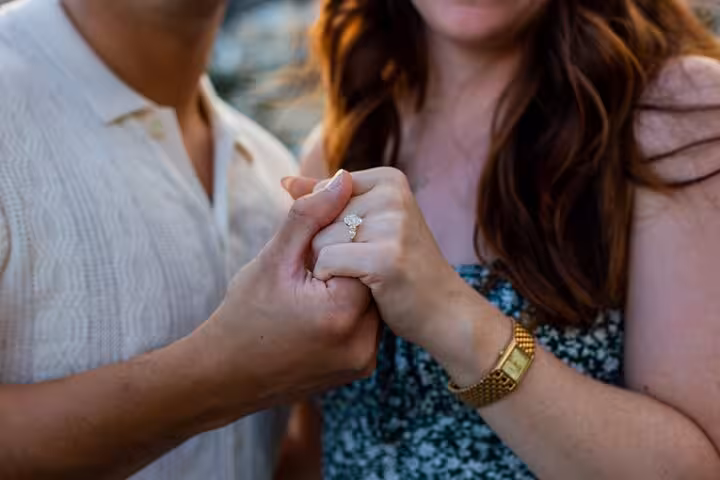 Close-up of engaged couple holding hands showcasing a sparkling ring during Amalfi Coast photo shoot.