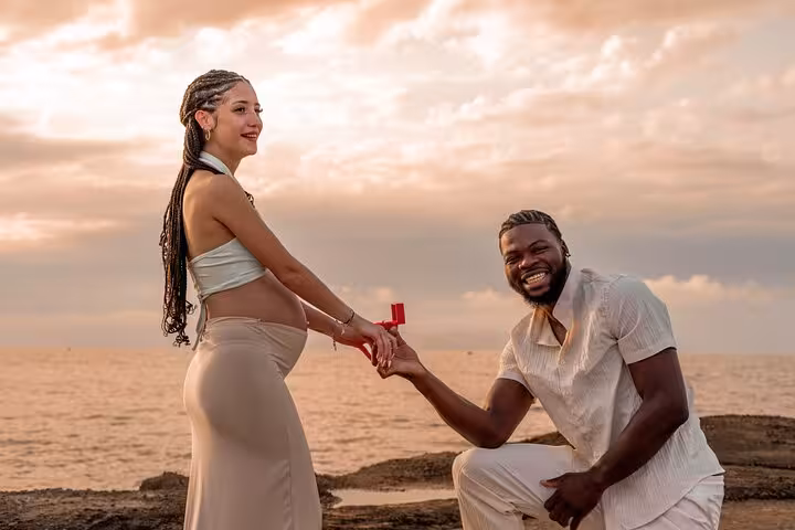 Happy couple celebrating engagement by the ocean at sunset in Analipsi, captured in a professional photoshoot.
