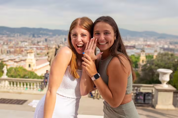 Happy engagement portrait at Barcelona viewpoint after proposal photo session, couple smiling with city panorama behind