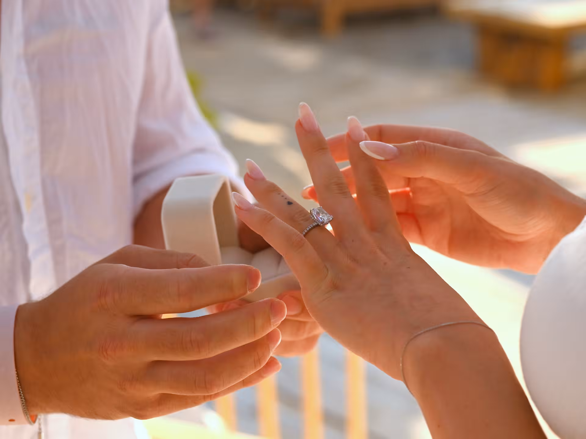 Close-up of an engagement ring being placed on a woman's finger during a surprise proposal photoshoot in Heraklion.
