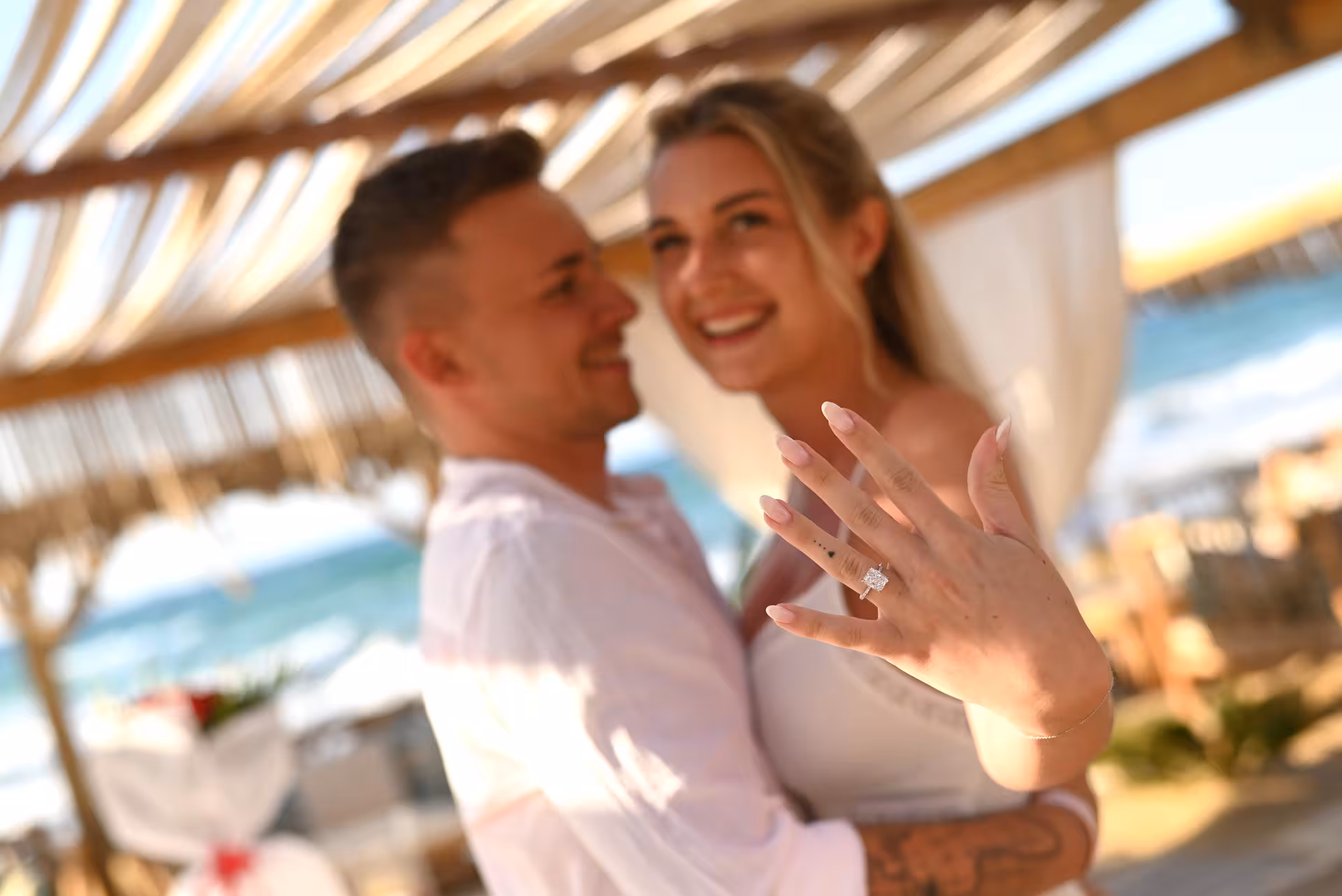 Smiling woman shows engagement ring during a surprise proposal at Heraklion Venetian Port.
