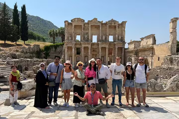 Visitors pose in front of the historic Celsus Library on a private tour from Kusadasi Port, featuring ancient ruins.