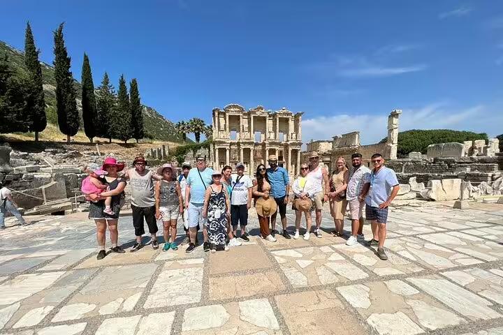 Visitors explore the historical ruins of Ephesus with a private guide and van from Kusadasi Port, standing by the Library of Celsus.