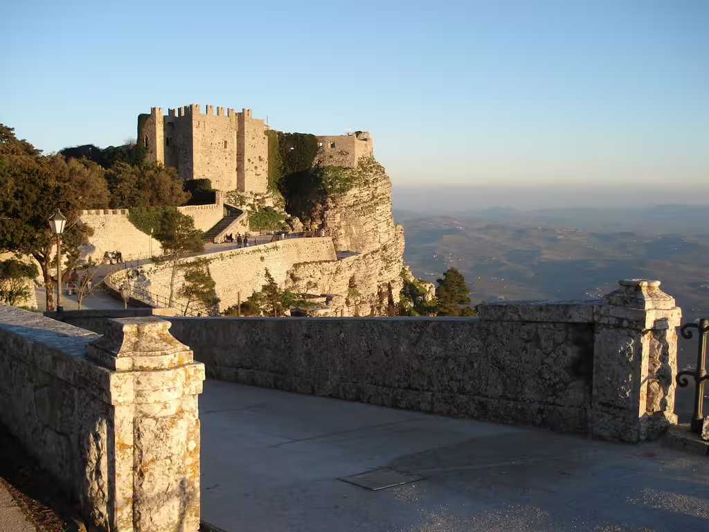 Sunlit medieval walls and castle of Erice perched above Sicily’s countryside on a Segesta and Erice private day trip