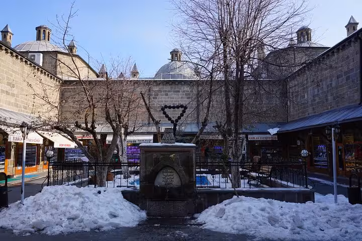 Snowy courtyard fountain at Erzurum’s historic bazaar with domed roofs, on an all-inclusive private 2-day guided tour