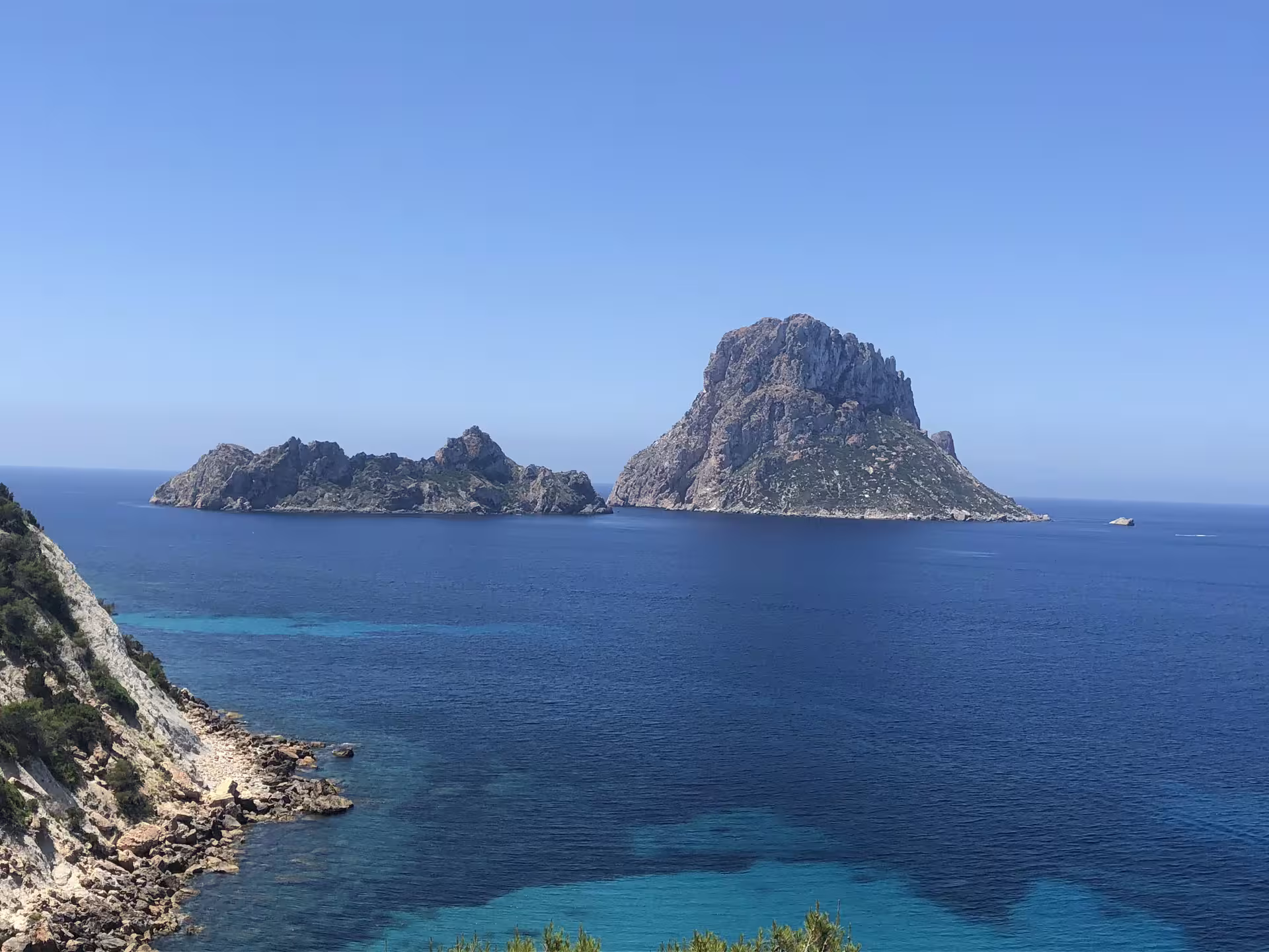 Es Vedrà rock island viewed over turquoise sea on Ibiza boat trip from San Antonio with guide, aperitif and drinks