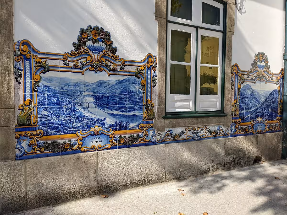 Traditional blue azulejo tile mural on Porto street wall, a cultural highlight of the Essence Tour in Portugal