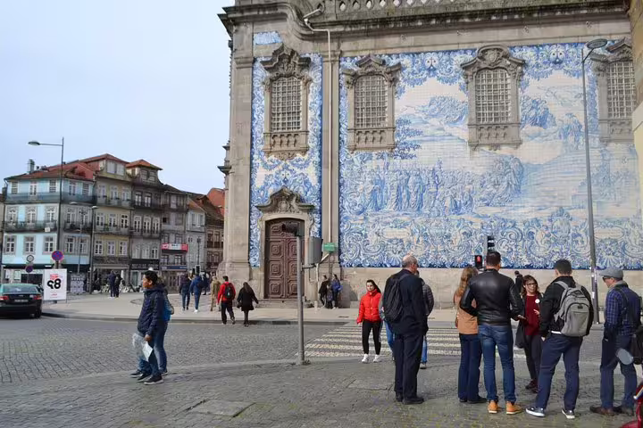 Tourists explore the stunning azulejo facade of Igreja do Carmo, an iconic stop on the Essential Porto Walking Tour.