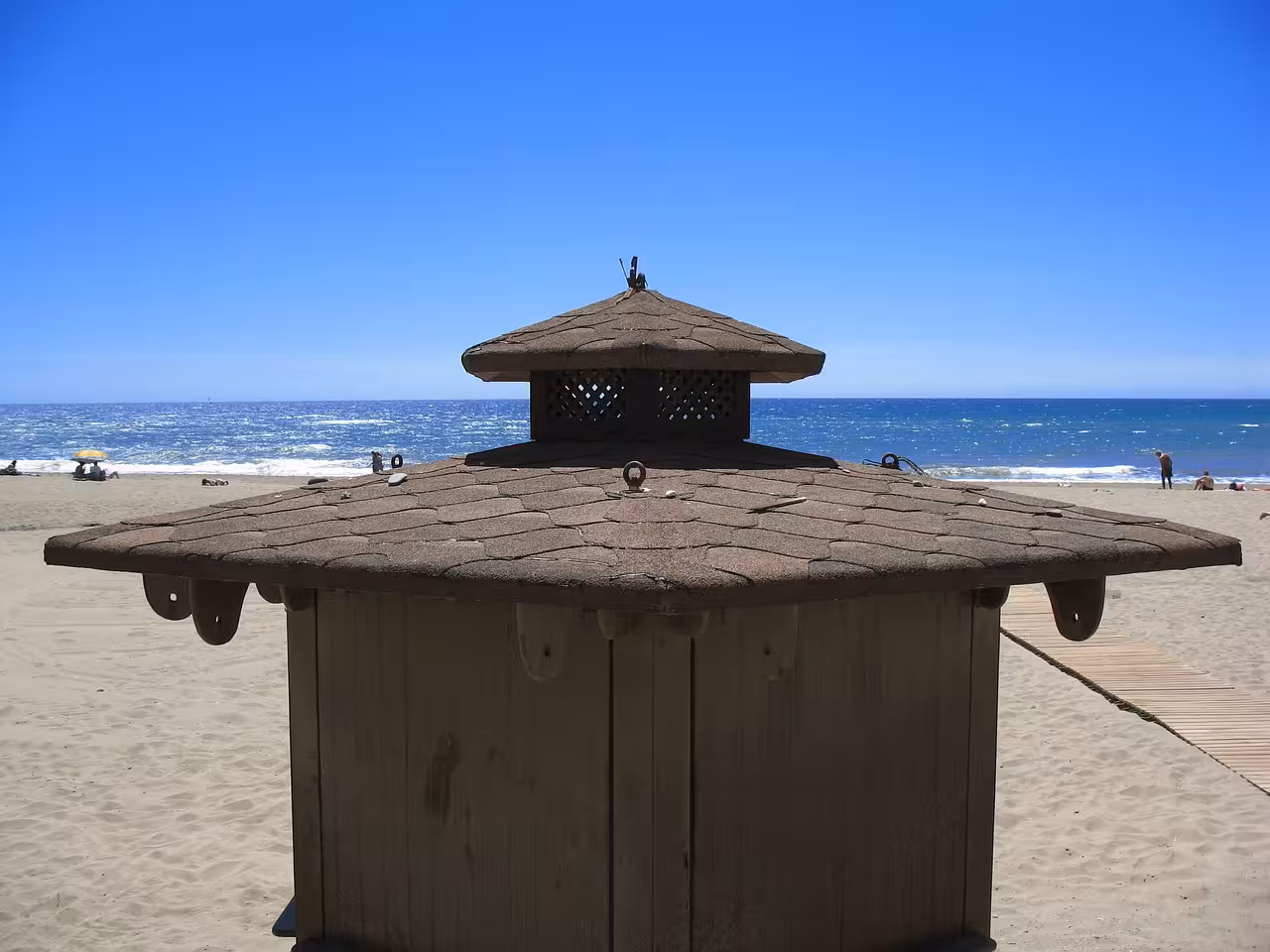 Rustic beach hut overlooking the serene coastline of Estepona under a clear blue sky.