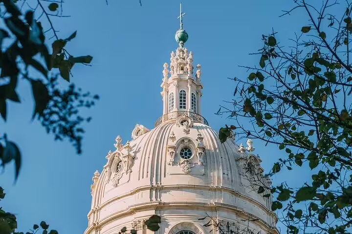 Baroque dome of Estrela Basilica framed by trees, highlighting Lisbon's architectural charm on a Tuk Tuk tour.