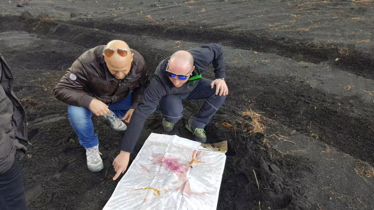 Guide and guests reading a map on Mount Etna lava terrain on Taormina Etna 4x4 jeep excursion