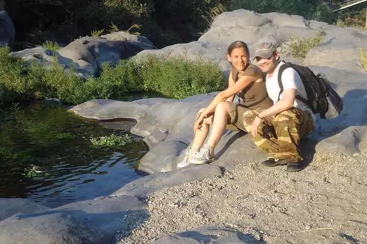 Two happy tourists enjoying a sunny day by the Alcantara River during the Etna and Alcantara River tour.