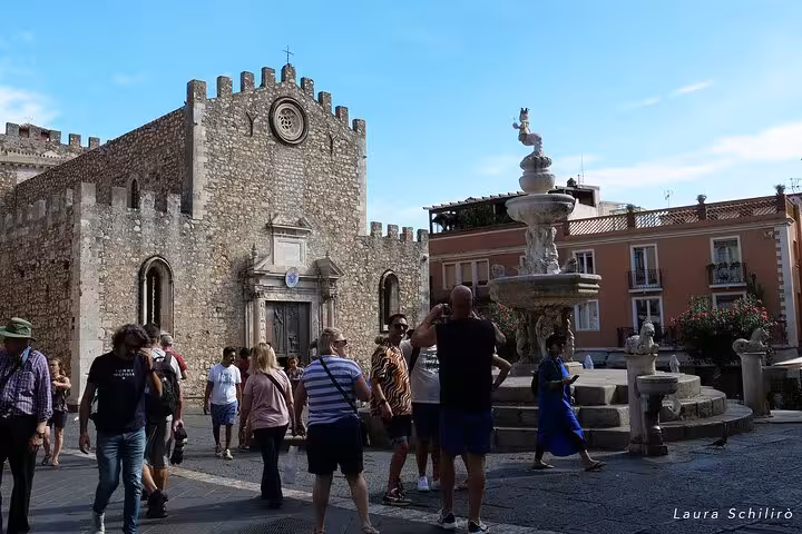 Tourists explore Taormina's medieval cathedral and iconic fountain, key attractions in the Etna and Taormina tour.