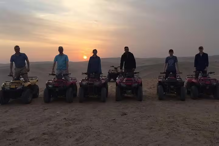 Evening quad biking tour in Cairo desert with group lined up on ATVs, sunset ride near Giza Pyramids