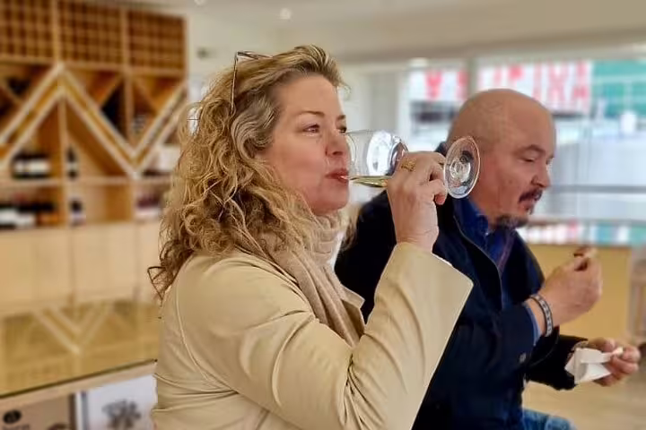 Couple enjoying wine tasting during the Private Full Day Évora and Alentejo Wine Tour from Lisbon in a cozy vineyard setting.