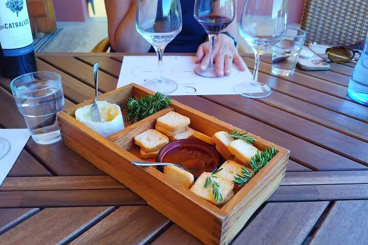 Wine tasting experience with snacks and rosemary at a table during the Private Full Day Évora & Alentejo Wine Tour from Lisbon.