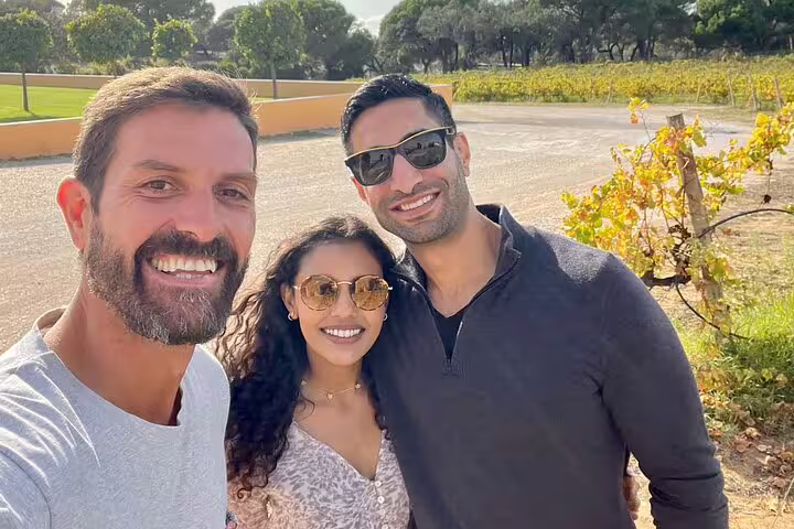 Smiling tourists enjoying a sunny day at a vineyard during the Private Full Day Evora & Alentejo Wine Tour from Lisbon.