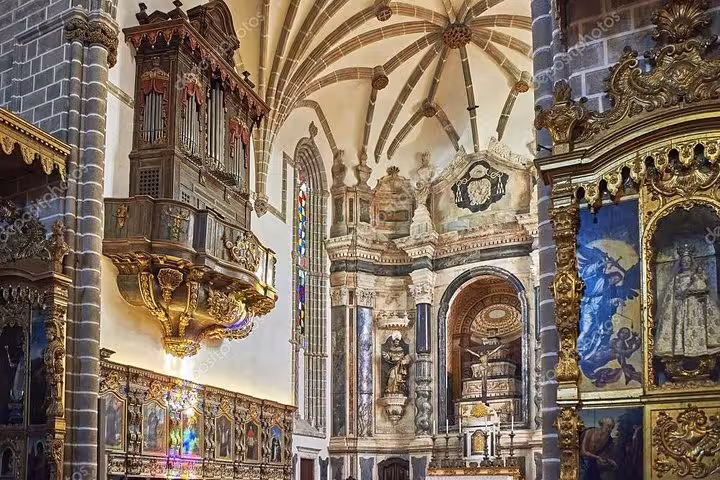 Intricate interior of a historic Évora cathedral with ornate carvings and stained glass, ideal for cultural excursions.