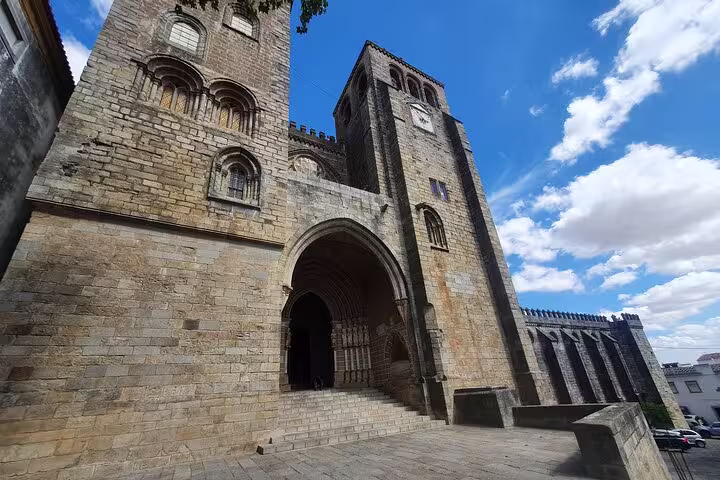 Historic stone cathedral facade in Évora under a bright blue sky, featured in the Evora & Monsaraz private full-day tour.