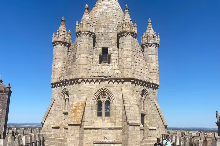 Majestic stone tower of Évora Cathedral under a clear blue sky, featured on a private tour from Lisbon.