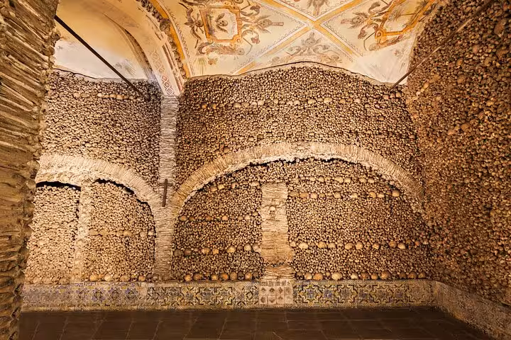 Interior of the Chapel of Bones in Évora, showcasing walls adorned with human skulls and bones for a unique experience.