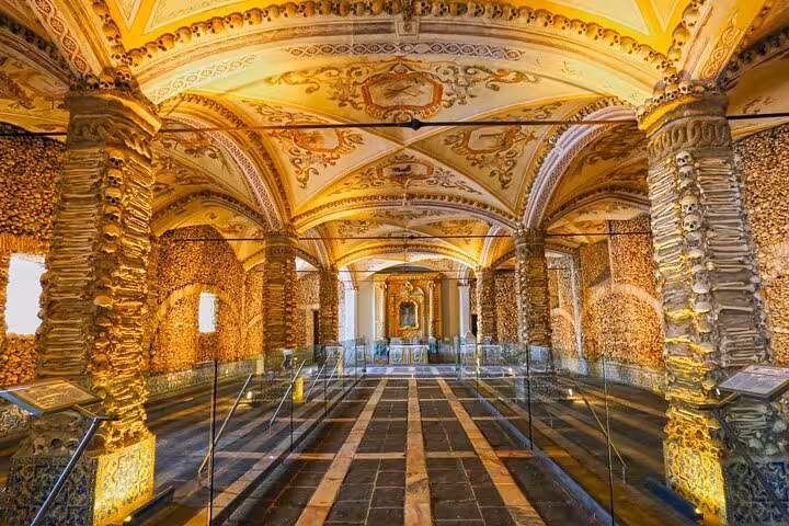 Interior view of Évora's Chapel of Bones, showcasing intricate bone-adorned columns and vaulted ceilings.
