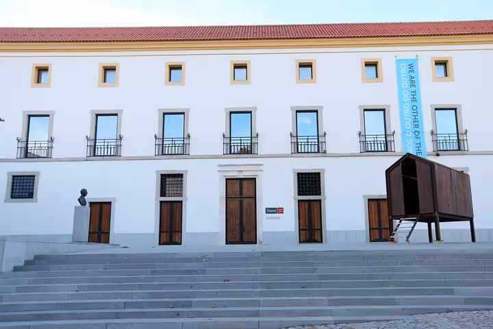 Facade of a historical building in Évora with modern art installations, ideal for an educational walking tour.