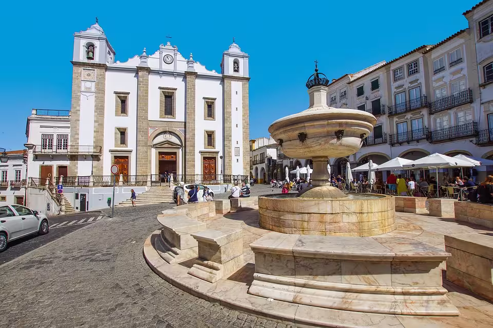 Charming fountain and Igreja de Santo Antão in Évora's historic square, a must-visit on Alentejo's cultural tours.