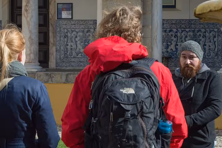 Tour group listens intently to a guide outside historic site in Évora, part of the Jewish history walking tour.
