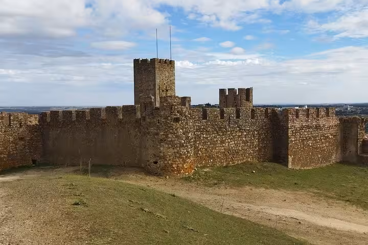 Majestic medieval castle walls in Évora with towers and battlements overlooking expansive countryside.