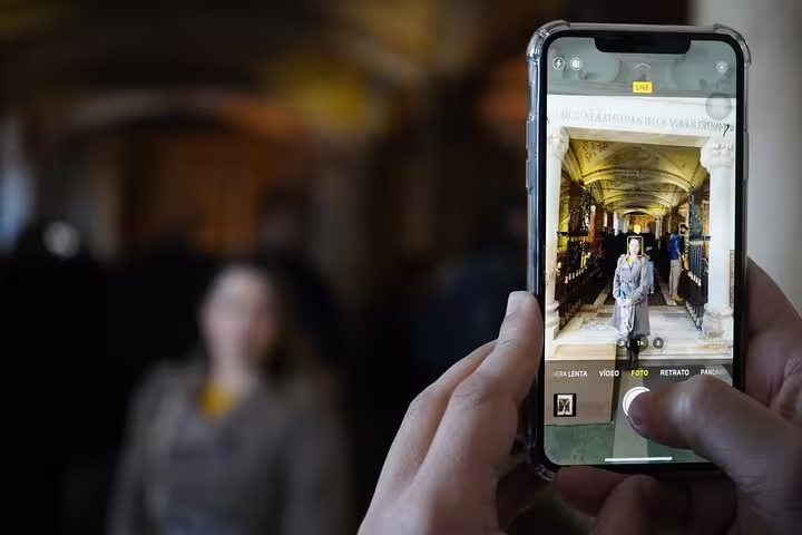 Capturing the intricate architecture of Évora's historic sites on a smartphone during a day trip from Lisbon to Monsaraz.