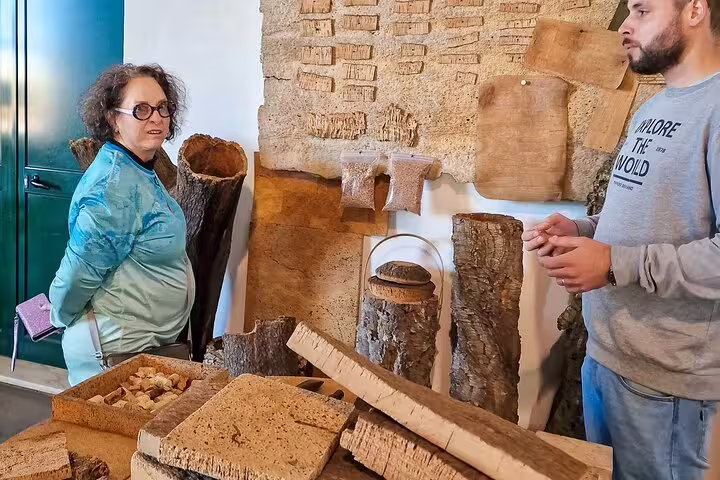 Visitors explore traditional cork processing in a workshop during a day trip from Lisbon to Évora and Monsaraz.