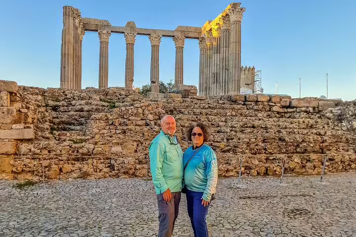 Couple exploring the ancient Roman Temple of Évora during a picturesque day trip from Lisbon to Évora and Monsaraz.