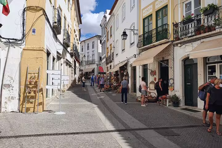 Charming street in Évora with historic architecture and quaint shops, perfect for exploring on a small-group tour from Lisbon.