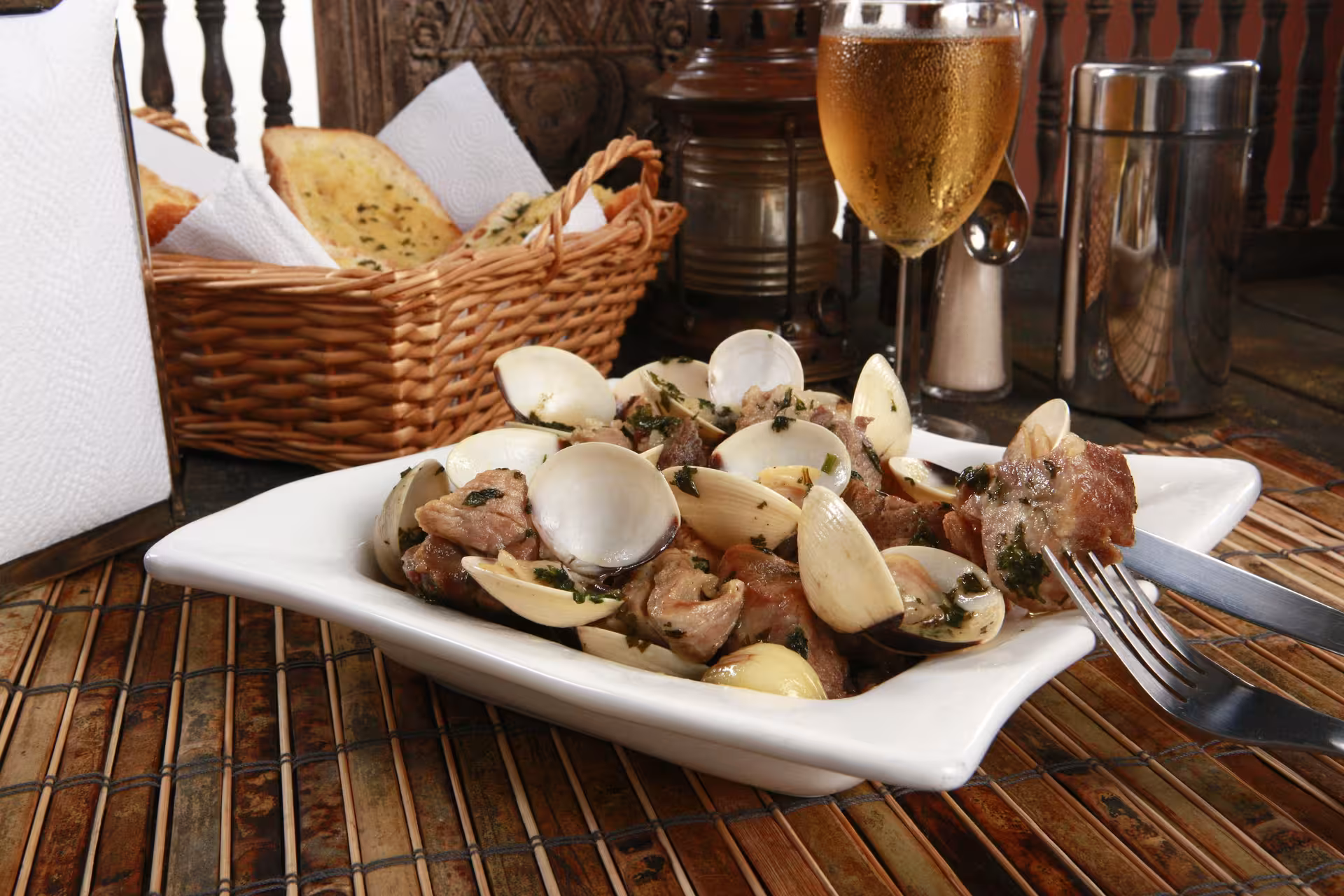 Portuguese dish of pork and clams served with bread and wine, showcasing local flavors of Évora cuisine.