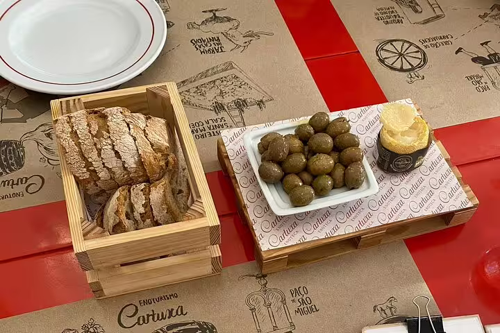 Traditional Portuguese bread and olives served at a restaurant in Évora, perfect for a cultural culinary tour from Lisbon.