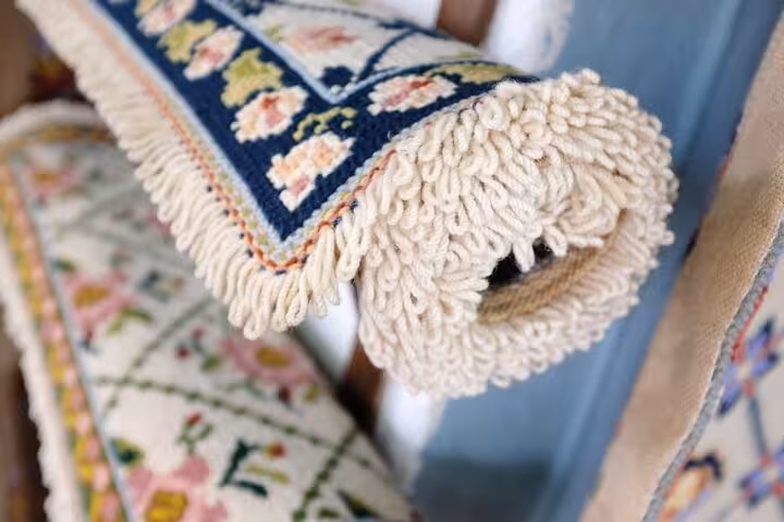 Close-up of intricately woven Portuguese rugs with floral patterns, showcasing Évora's rich handicraft heritage.
