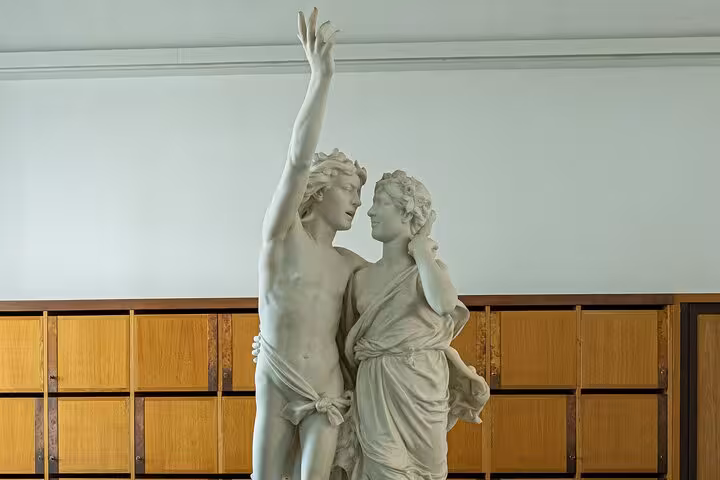 Intricate marble statue of two figures embracing, showcasing Roman artistry on the Évora walking tour.