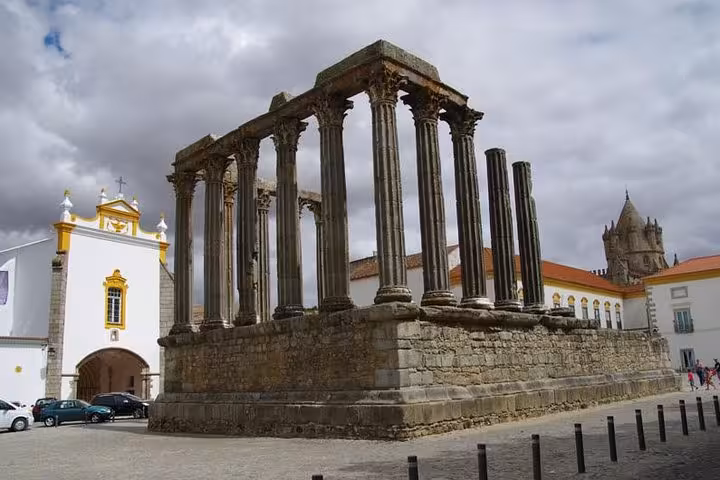 Ancient Roman Temple of Évora under cloudy skies, a key landmark on private city excursions.