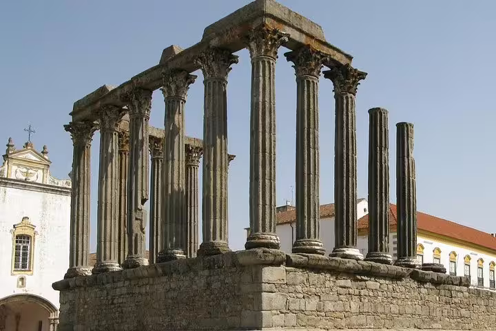 Ancient Roman temple ruins with towering columns in the historic city of Évora, a highlight of the Algarve tour.