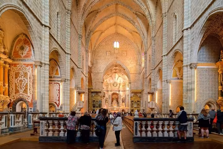Tourists explore the stunning interior of a historic church in Évora, part of the small group walking tour experience.