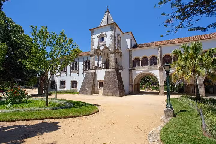 Historic white building in Évora surrounded by lush greenery, featured on the small group walking tour with Chapel of Bones tickets.