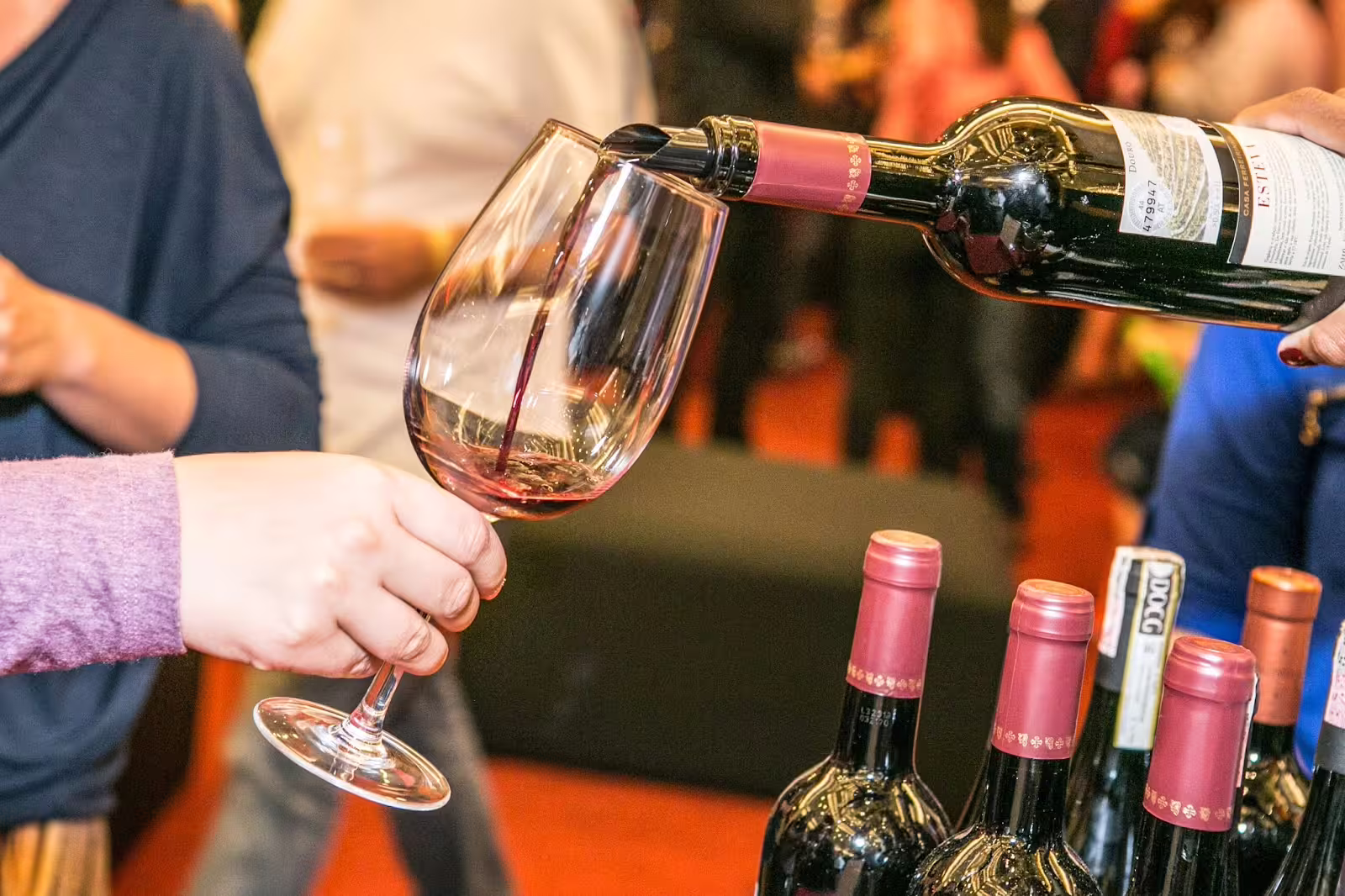 Close-up of red wine being poured into a glass during Lisbon's Évora wine tasting tour for an enriching experience.