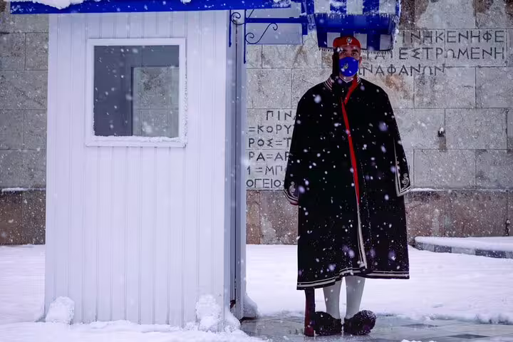 Evzone guard at Syntagma in winter snow, photo stop on Athens half-day private car tour with local driver-guide