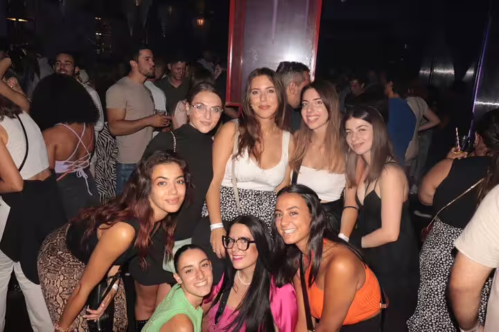Excited group of women at a bustling Madrid nightclub, capturing the vibrant atmosphere of a pubcrawl tour.