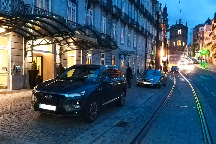 Luxurious executive car parked outside a stylish city hotel, perfect for an 8-hour private chauffeur service experience.