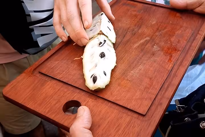 Close-up of a sliced exotic fruit on a wooden board, showcasing unique textures during the Rio Tropical Fruit Tour.