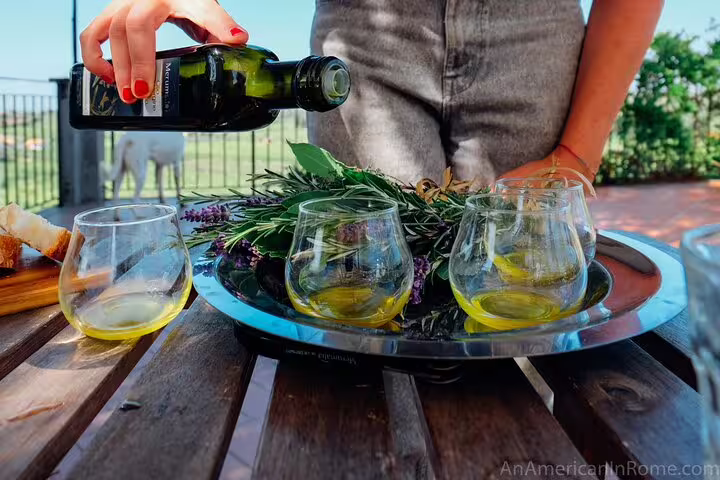 Pouring extra virgin olive oil into tasting glasses at a Nafplio farm experience near Corinth Canal