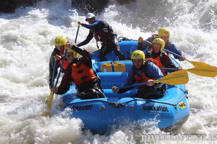 Adventurous group tackling intense rapids on extreme river rafting trip, showcasing thrilling outdoor experience in whitewater.