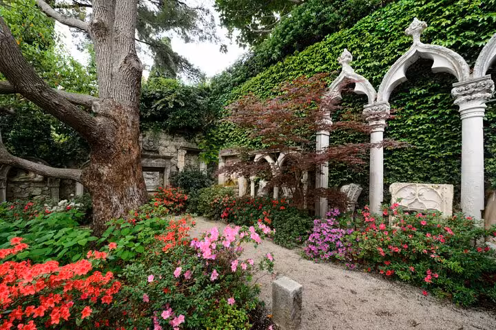 Enchanting garden in Eze with vibrant flowers and historic stone arches, perfect for a Monte-Carlo private tour.